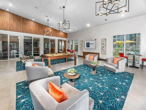 a living room with couches and chairs and a pool table